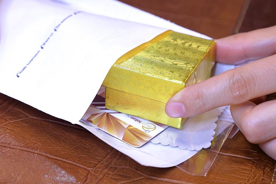 Nyitott buborékfóliás tasakba csúsztatva a tisztítókendő, garanciakártya és a díszdoboz