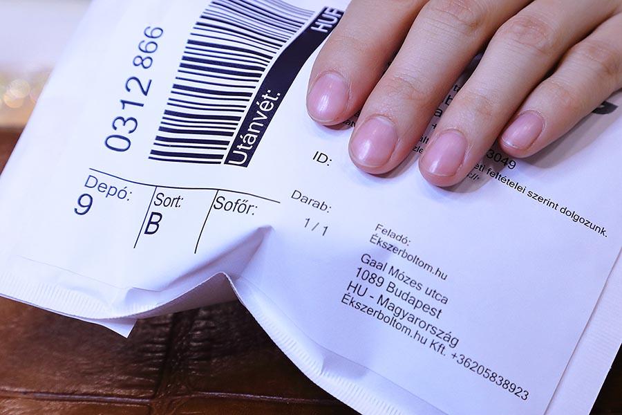 Csomagcímkével ellátott, lezárt boríték (személyes adatokra, és adott szállításra vonatkozó információk felismerhetetlenné vannak retusálva)