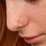 Kép 5/8 - Diversa Triskelion sárga 18 kt arany orrpiercing viselve