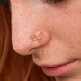 Kép 5/8 - Diversa Triskelion rozé 18 kt arany orrpiercing viselve